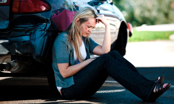 car insurance - car accident victim sitting on the ground