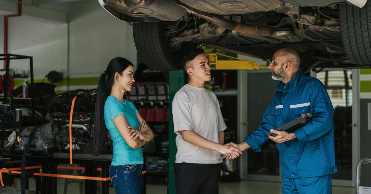 two young adults at auto body shop