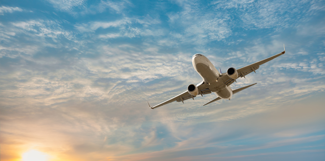 airplane in the sky about to land at sunset