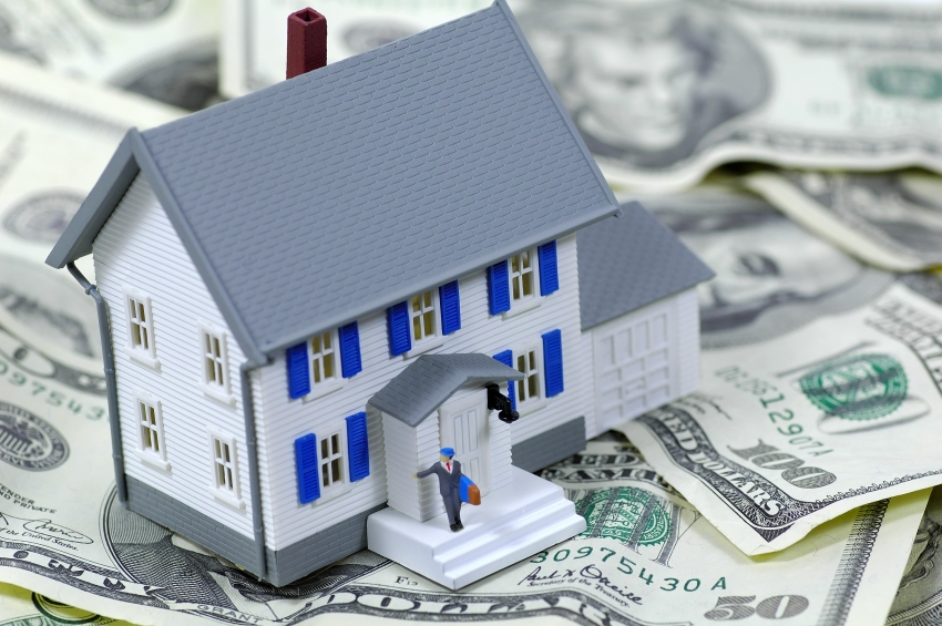 Investment property Insurance - toy house on dollar bills