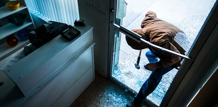 Man breaking into a business- Business Insurance Claims