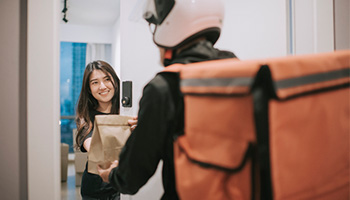 A delivery driver completing a food delivery.