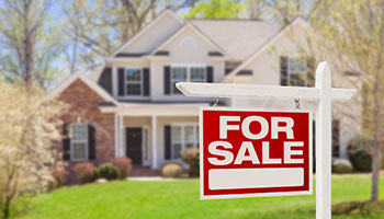 Image of a For Sale sign in front of a house. 