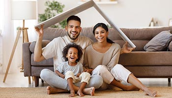 Family underneath a cover that represent a home's roof. 