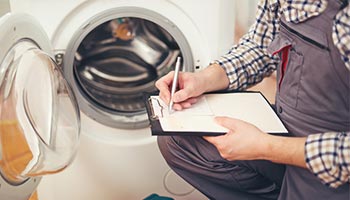 image of a worker preparing to repair a washing machine covered by a home protection plan. 