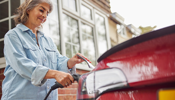 Woman plugging in her electric car to charge