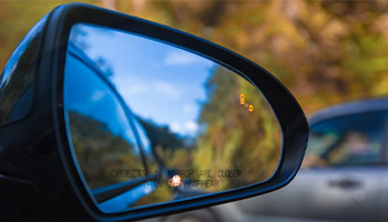 Objects in mirror are closer than they appear on car with Blind Spot Assist Warning LED Sensor Light.