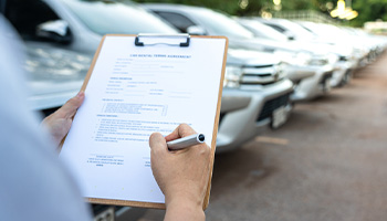 rental car employee reviewing rental car reimbursement documents.