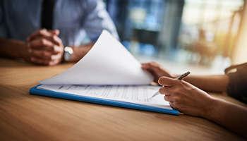 Insurance agent completing SR22 paperwork together at a desk.