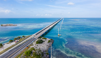 View of the Overseas Highway, a scenic road perfect for a summer road trip that is surrounded by water. 