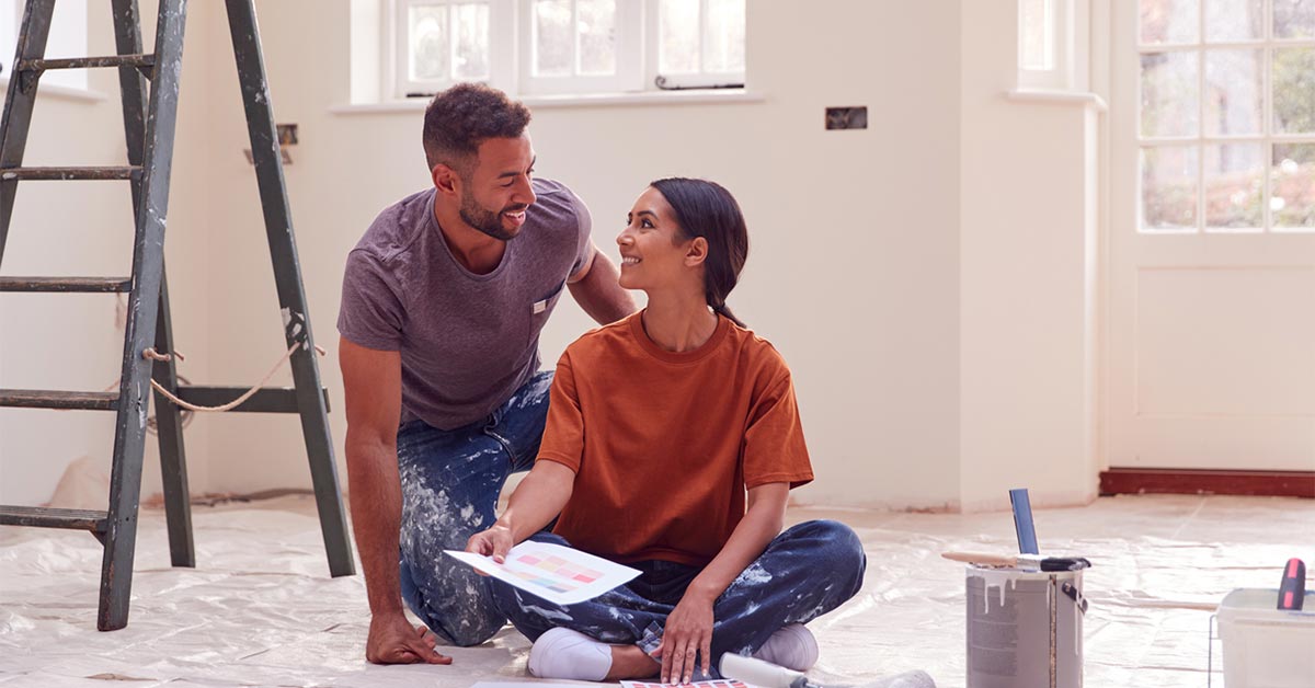Couple sitting on the floor ready for a new home improvement project
