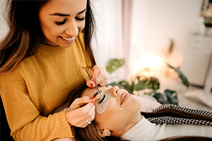 eyelash technician putting on lash on client