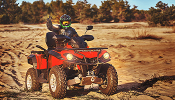 person on an ATV throwing peace sign