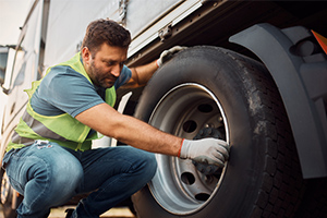 truck driver inspecting tires