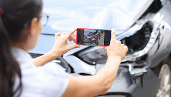 a person taking photos for filling an auto collision insurance claim 