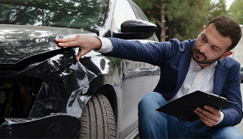 a person reviewing a car after purchasing too little insurance, common auto insurance mistakes