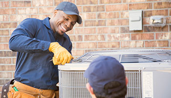 an hvac worker repairing an air conditioning unit 