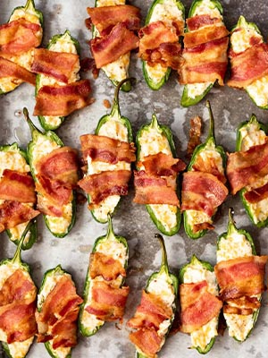 bacon wrapped jalapeno poppers on a baking dish 
