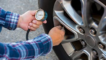 a person checking their tire pressure