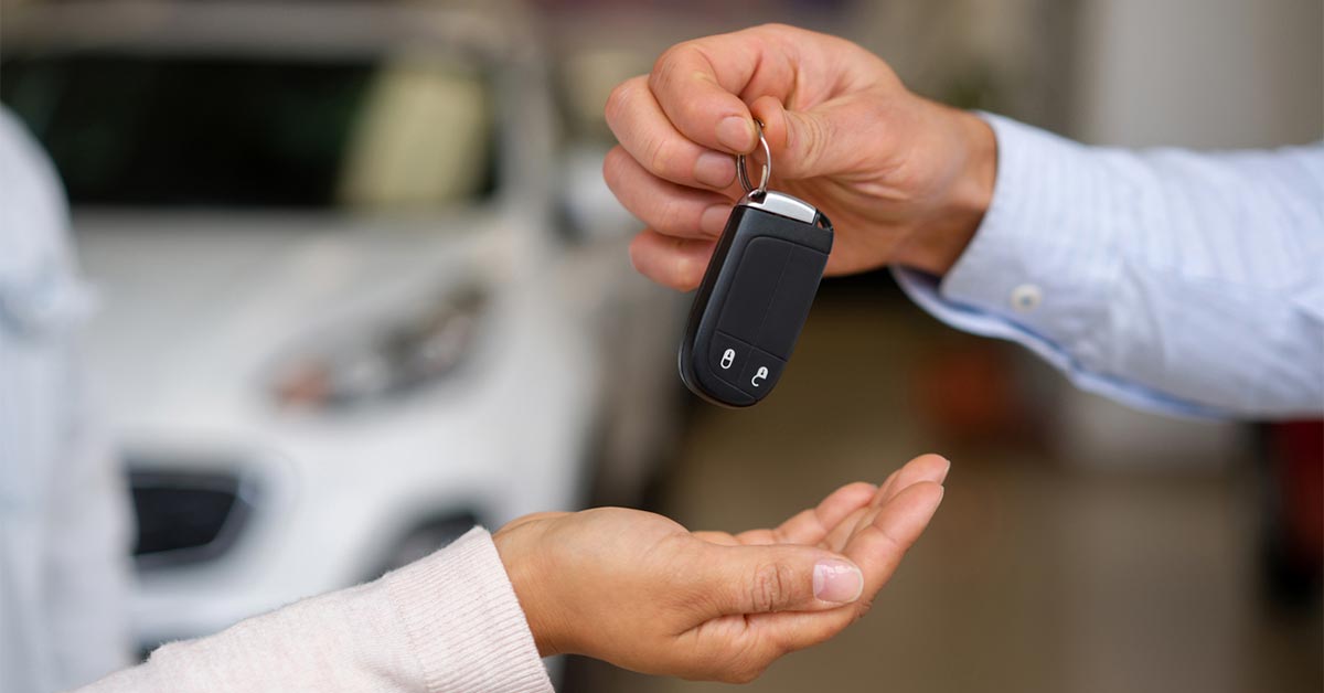 a person renting a car and being handed the keys
