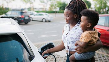 a mother and her child charging their electric vehicle in California