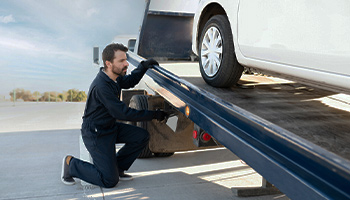 A tow truck towing a car the broke down on the highway