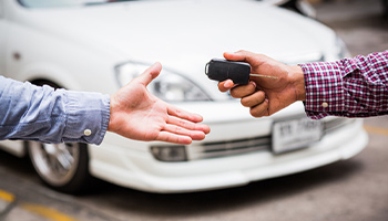 a person letting someone borrow their car and handing them the keys