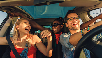 friends in a car someone let them borrow for a road trip