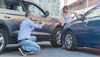 two persons documenting a car accident