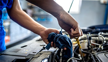 a person checking on a car's motor oil