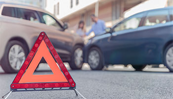 A hazard cone in the road after a car accident