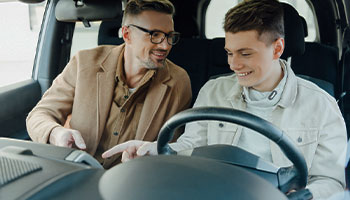 a young driver and their father in the car together