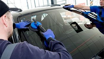 a crew of workers fixing a car's windshield