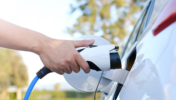 a person plugging in their EV to charge