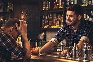bartender serving liquor to intoxicated man