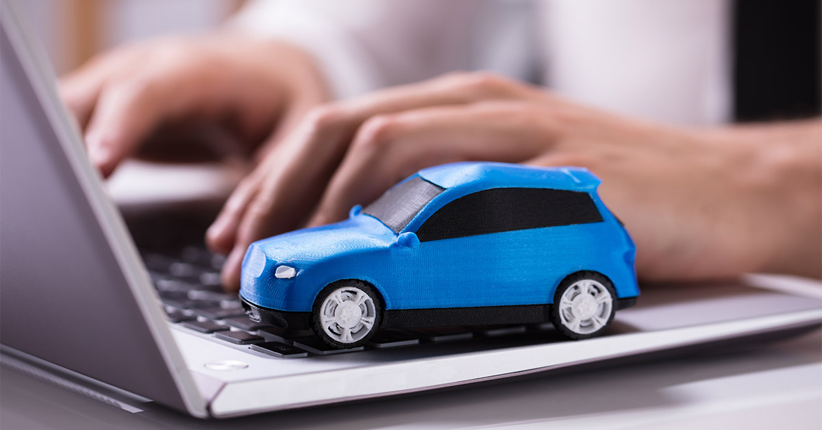 toy car on computer indicating user is researching or switching car insurance companies
