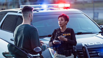 an individual talking to a police officer after their car was stolen