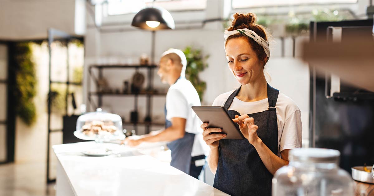 coffee shop owner getting business insurance quote on tablet
