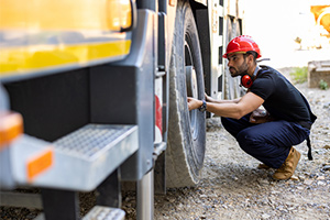 inspecting truck's tires - business auto insurance rate