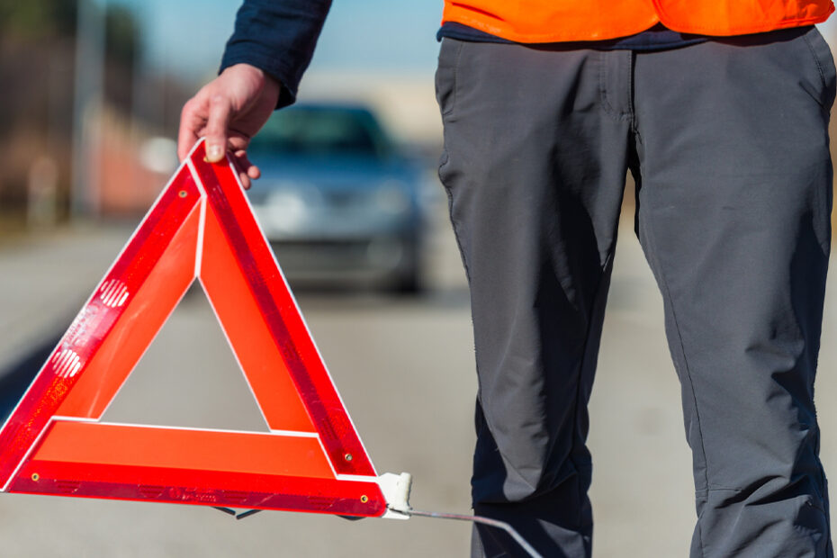 man installing a traffic hazard triangle