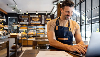 cafe owner checking discounts - lower your business insurance