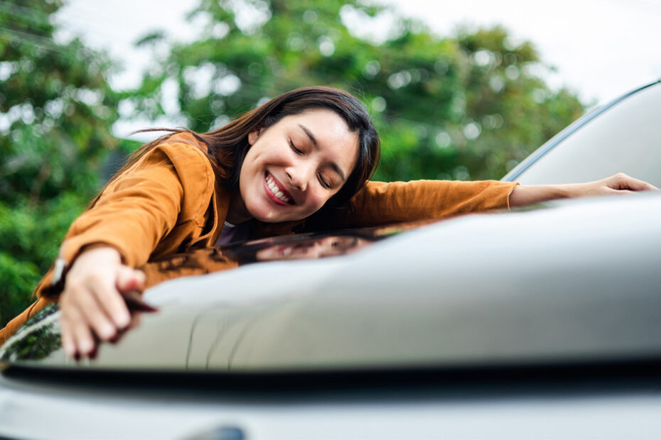 college student hugging new car