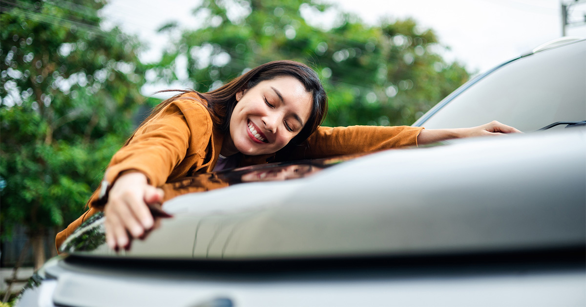 college student hugging new car