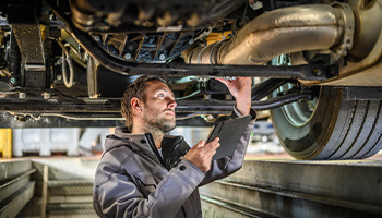 car mechanic looking at old car