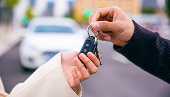 does car insurance follow car or driver when you give someone keys and let them borrow your car concept photo showing someone giving keys to someone else
