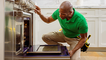 a home protection plan service provider inspecting an oven 