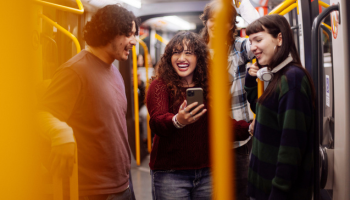 ground of young adults talking and laughing on a public train