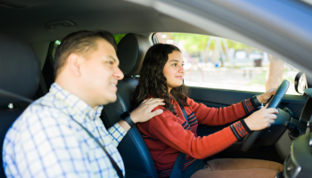 a father teaching his daughter how to drive 