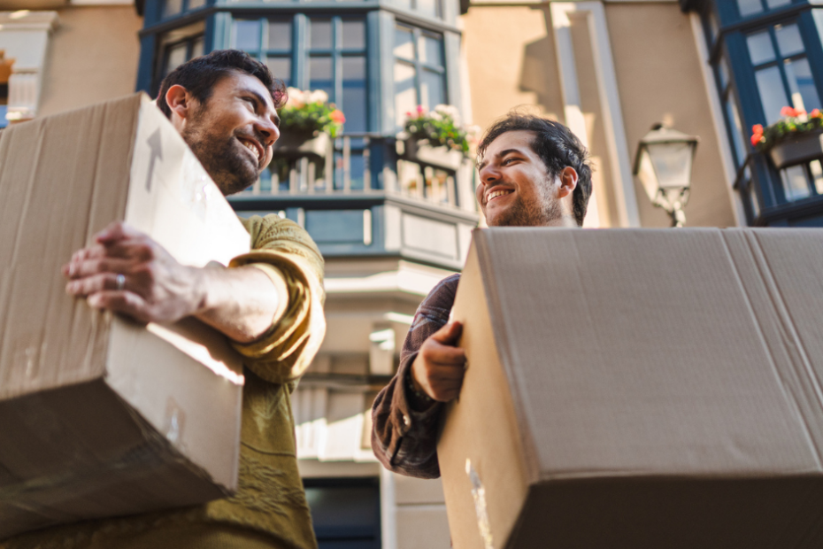 two people with moving boxes about to move into their new apartment