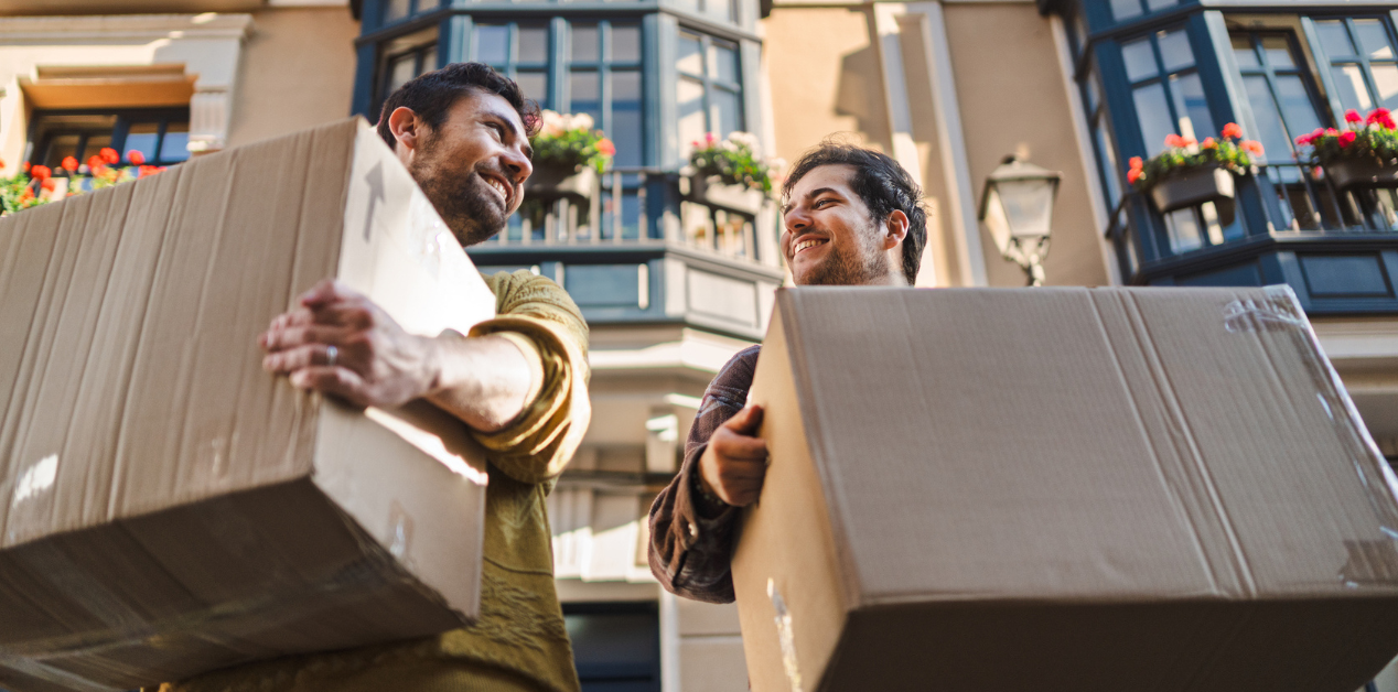 two people with moving boxes about to move into their new apartment
